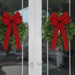 two front doors with a wreath that has a red velvet bow